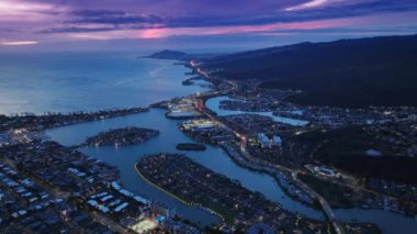 Günbatımından sonra Doğu Honolulu 'nun üzerinde destansı bir gün batımı. Tropikal adadaki gece kasabasının havadan görünüşü. Hawaii Kai kulübelerinin üstündeki İHA, Oahu Adası. Sinema pembe günbatımından sonra Honolulu banliyö antenleri