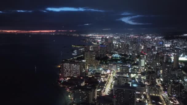 下城威基基海滩在晚上 夕阳西下 火奴鲁鲁的地平线映入眼帘 空中华胡市的夜景 黄昏时分 海滨海湾城市美丽的城市景观 夏威夷岛上的城市照明 — 图库视频影像