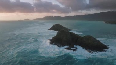 Gün doğumunda Na Mokulua Adaları 'na düşen insansız hava aracı dalgaların üzerinde yükseliyor. Oahu Adası, Hawaii Birleşik Devletleri. Pasifik Okyanusu 'ndaki küçük adalar. Hawaii tatili. Turizm arka planı destansı gün doğumu