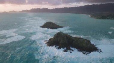 Gün doğumunda Na Mokulua Adaları 'na düşen insansız hava aracı. Oahu Adası, Hawaii 'de yaz tatili. Pasifik Okyanusu 'ndaki küçük adalar. Hawaii tatili. Turizm arka planı destansı gündoğumu 4K
