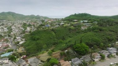 Tropik ada kentsel geçmişi ve tropik kırbaç evleriyle dolu. Güzel dağların manzarası. Hawaii adasının Oahu rüzgarlı kıyılarındaki Kailua köyündeki küçük sahil kulübelerinin hava manzarası.