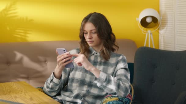 Roztomilá Mladá Dáma Překvapí Zatímco Procházení Smartphone Sedí Stolu Doma — Stock video