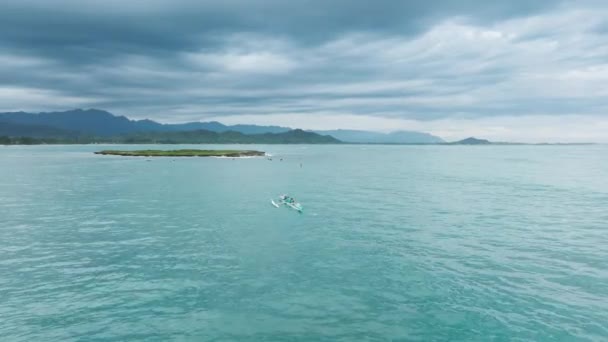 独木舟在美丽的淡蓝色海水中驶向波波亚岛 周末进行水上运动和户外活动 美丽的Kailua村背景绿色夏威夷山脉 — 图库视频影像
