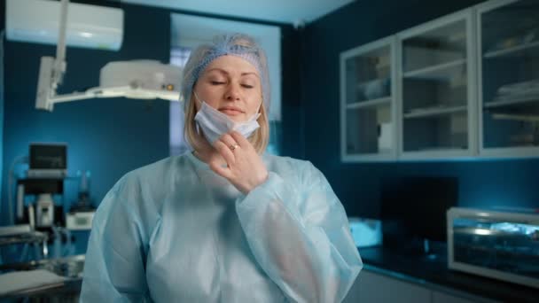 Enfermera Confiada Gabinete Médico Mirando Cámara Quitándose Máscara Facial Durante — Vídeos de Stock