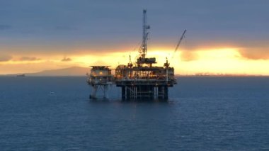 Santa Catalina Körfezi 'ndeki güzel gün batımında deniz aşırı petrol sondaj kulesinin havadan görüntüsü. Madencilik. Kaliforniya 'da karlı petrol ve petrol endüstrisi. Yüksek kalite 4k görüntü