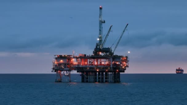 太平洋の海域でのオフショア石油掘削リグでの夜の生活 照らさ巨大な鋼構造と船 米国の電力産業 高品質4K映像 — ストック動画