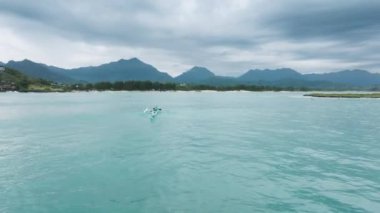 Hafta sonları su sporları ve açık hava aktiviteleri. Yeşil Hawaii dağları olan güzel Kailua köyü. Kano, Kailua Körfezi 'nin güzel mavi okyanus sularında Popoia adasına yelken açıyor.
