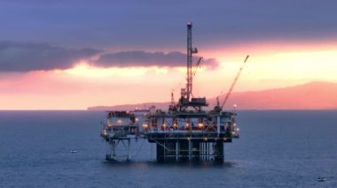 Aydınlatılmış petrol kuyusu yapısı, uzak sisli ada manzarası ve inanılmaz güzellikteki gemiler. San Pedro Kanalı 'nda şafak vakti. Yüksek kalite 4k görüntü
