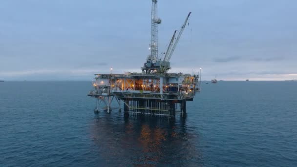 太平洋の深海石油鉱床を探索し 処理施設を完備した照明付きの石油掘削リグの夕景 アメリカだ 高品質4K映像 — ストック動画