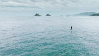 Su sporu aktivitesi. İnsansız hava aracı kamerasında aşırı spor aktivitesi görüntüsü. Oahu 'da su sporları, Hawaii adası. Sörfçü levhada sörf yapıyor. Atletik adam okyanus dalgalarının gücüyle folyoya biniyor.