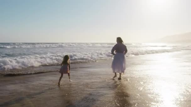 红外摄像机拍到了快乐的家庭团队合作镜头 梦想成为飞机驾驶员的孩子 美丽的女儿和母亲在日落时在海滩上的轮廓 在海浪中和妈妈一起跑的小女孩真可爱 — 图库视频影像