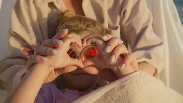 かわいい幸せな女の子の心の形で小さな手を保持し カメラを見て 日没の子供の心の形で手を折り畳んだ 笑顔の女の子は幸せな家族の愛のシンボルを示しています 家族愛のハートサイン Red — ストック動画