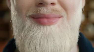 Sarı sakallı, gülümseyen yakışıklı adama yaklaş. Gelişigüzel pozitif albino erkek çeşitliliği. Hollywood gülümseme kavramı, beyaz düz dişler, gülümseyen dudaklar. Duygusal Eğlence, Neşe Yaşam Tarzı