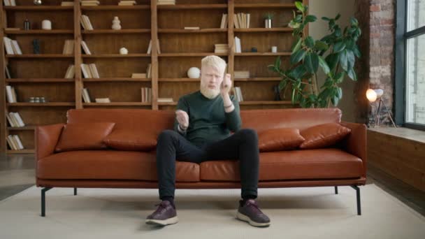 Албіно Хлопець Грає Невидимих Барабанах Розважаючись Дивані Квартирі Лофт Розважальний — стокове відео