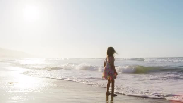 红外摄像机上慢镜头拍摄的快乐儿童梦的概念 可爱的孩子在阳光下沿着海滨奔跑 快乐的家庭观念 孩子的梦想 小女孩在美丽的夕阳西下在沙滩上奔跑 — 图库视频影像