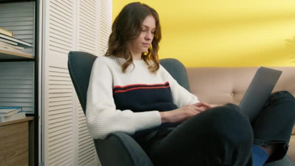 Kobieta Pisząca Laptopie Domu Skupiona Kobieta Pracująca Komputerze Fotelu Przemyślana — Wideo stockowe