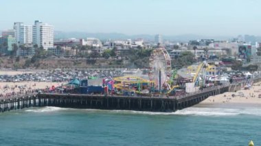 Santa Monica, LOS ANGELES, CALIFORNIA, USA-26 HAZİRAN, 2023: Santa Monica rıhtımındaki ve Pasifik Parkı 'ndaki havadan görüş. Kalabalık eğlence parkında hafta sonunun keyfini çıkarıyor.