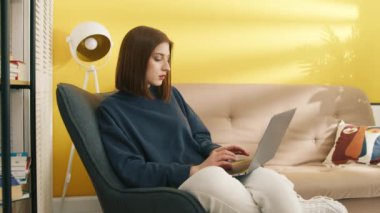 Evde dizüstü bilgisayarla çalışan zeki bir kadın. Bilgisayar klavyesinde yazan zeki kız. Kız öğrenci aletle internetten öğreniyor. Bilgisayarda internette gezinen ciddi bir kadın. Çalışma konsepti, 4k görüntü
