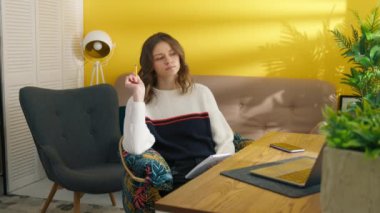 Kolaj öğrencisi evde ödev yapıyor. Not defterine not alan düşünceli bir kadın. Akıllı kız masada ders öğreniyor. Genç bayan sınavlara hazırlanıyor. Çalışma konsepti, 4k görüntü 