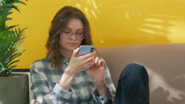 Menina Inteligente Sentado Sofá Com Smartphone Estudante Colagem Óculos Conversando — Vídeo de Stock