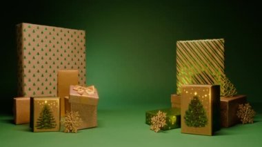 El yapımı kağıda sarılmış iki deste altın sarısı Noel hediyesi. Çam yeşili arka plan metnin için merkez bölge. Noel gecesi, aile sevgisi kavramı Kırmızı Kamera 4K