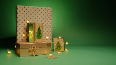 Koyu yeşil arkaplan üzerine yazdığın metin için boş alanı olan el sanatları kağıdına sarılı bir yığın parlak Noel hediyesi. Noel ağacı desenli kutular ve ren geyikleri açık renk çelenk