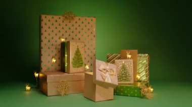 Sürpriz hediyeler Noel arifesi, yeni yıl partisi, aile sevgisi RED 4K. Mutlu 2024 Yeni Yıl kartpostal geçmişi. Yeşil arkaplanda yeşil Noel ağacı desenleri olan hediye kutuları yığını