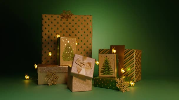Stapel Von Geschenkboxen Mit Grünen Weihnachtsbaummustern Isoliert Auf Grünem Hintergrund — Stockvideo