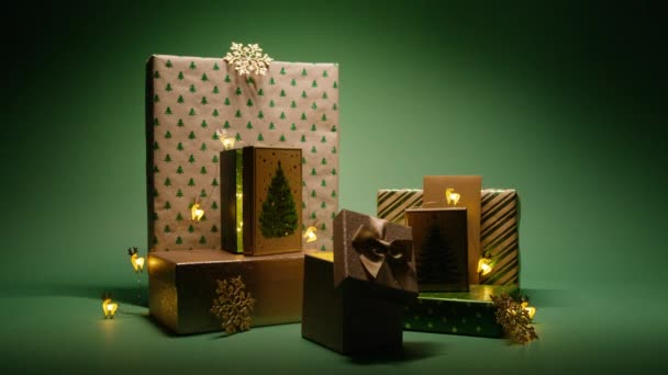 神奇的圣诞灯在绿色背景上滑动礼品盒 圣诞夜的礼物堆积如山 新年派对 全家人都爱红色4K 快乐2024新年明信片概念背景 — 图库视频影像