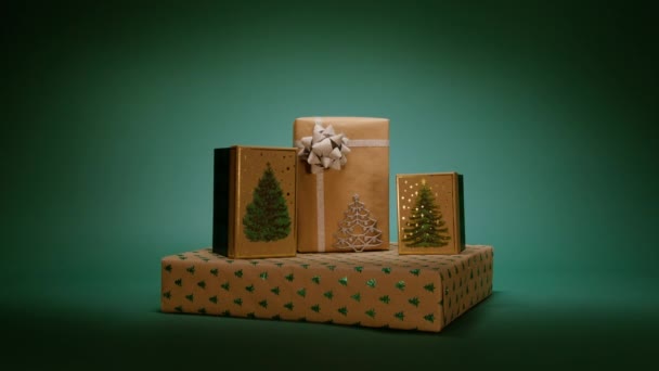 新年パーティーのサプライズギフト ハッピー2024 新年のエレガントでシンプルなコンセプトの背景 緑のクリスマス ツリー パターンが付いているギフト用の箱の積み重ねが付いている魔法のクリスマスのイブは暗い背景を隔離しました — ストック動画