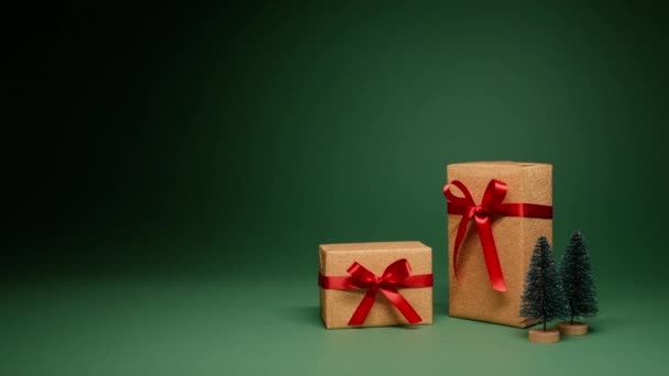 红色的缎子蝴蝶结 中央空旷的空间 在红色相机上的娃娃镜头中间堆满了威严的金光闪闪的礼品盒 松树装饰在绿色的背景上 圣诞仙境礼物 — 图库视频影像
