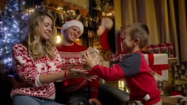 Mutlu genç anne, küçük sevgi dolu oğlundan altın bir hediye kutusu alıyor ve Noel arifesindeki hoş sürpriz ve ilgiye şükranlarını sunuyor. Kış tatili, Noel kutlaması 4K