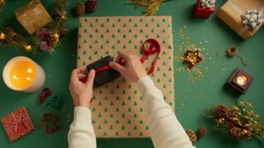 Kız arkadaşın için erkek eli Noel hediyelerini paketle. Noel süsleri, festival sezonu için hazırlık, RED çekimi. En tepeden bakan adam, karısı, arkadaşları ve akrabaları için Noel hediyesi paketliyor.