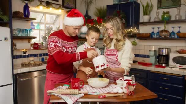 可爱有趣的小儿子学会了用手揉面 在圣诞节假期里在厨房里快乐地帮助父母 有小孩的漂亮家庭一起准备4K姜饼 — 图库视频影像