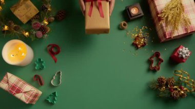 Erkek eller hediyelerini altın sarısına sarıp kırmızı kurdeleyle kadın ellerine veriyor. Kırmızı kurdeleyle bağlanmış kişi. Aile tatili kavramı, mükemmel Noel, yeni yıl, kutlama