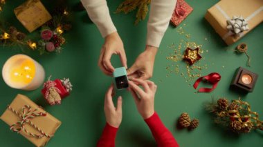 Erkek ellerinin nişan yüzüğüyle mavi kutuyu açtığı en tepeden aşağı manzara. Sevgi dolu bir adamdan Noel 'de inanılmaz bir sürpriz. Tanımlanamayan bir erkek kadına evlenme teklif ediyor. Aşk konsepti: Kırmızı kamera 4K yavaş çekim