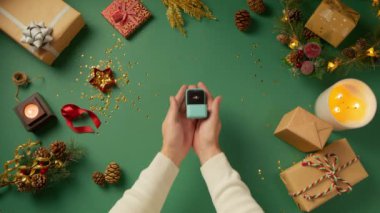 Yakışıklı erkek ellerinin, yeşil arka planda, Noel süsleriyle sevgilisine evlenme teklif ederken çekilmiş özgün bir fotoğrafı. Yüzüğü kabul eden ve evet diyen bir kadın. Kırmızı kamera 4K 'yı çekti.