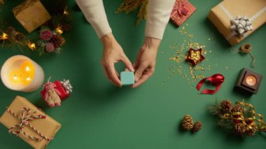 Damat, güzel bir alyans ve parmağında elmas yüzük ile evlenme teklif ediyor. Yüzüklü evlilik elleri. Gelin ve damat elleri tatil sezonunda yeşil arka planda, Noel dekorunda