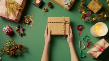 El sanatları konusunda üst düzey Noel dekorasyonları. Kırmızı kazaklı güzel kadın elleri el işi kağıdıyla Noel hediyeleri süslüyor. Tatil sezonu, kış harikalar diyarı, fotokopi alanı ağır çekim