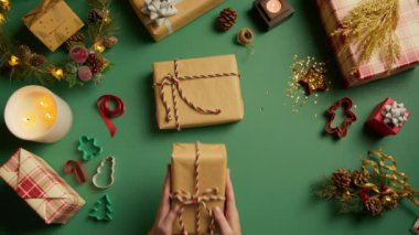 Yaratıcı sıfır atık Noel konsepti. Kırmızı kameraya 4K yukarıdan çekilmiş. Hediye kutularını şeker kamışı ipli el yapımı çevre dostu el yapımı el yapımı el sanatları kağıdıyla sarmak. Mevsimlik satış, tatil teklifi, yeni yıl alışverişi 4K