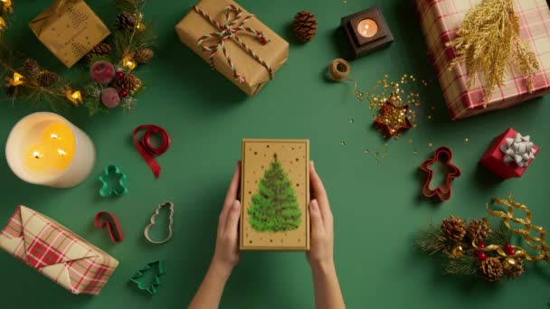 Overhead Weibliche Hände Öffnen Grüne Und Goldene Geschenkbox Mit Weihnachtsbaum — Stockvideo