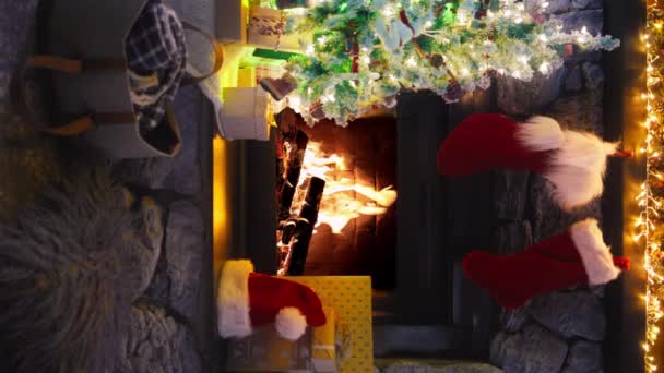 居心地の良いクリスマスと新年のインテリアの装飾の垂直背景 おもちゃ ギフトボックス ライトガーランドで装飾された再利用可能なクリスマスツリー 燃える火と輝くイルミネーションの暖炉 — ストック動画