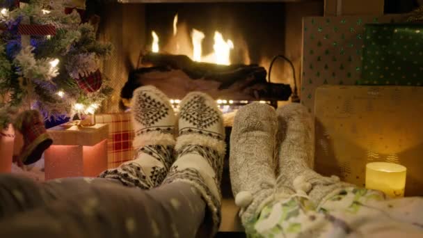 第一人穿着舒适的圣诞羊毛袜站在壁炉边 旁边点缀着圣诞树 背景上燃着明亮的火焰 拍下了4K的电影红色相机 — 图库视频影像