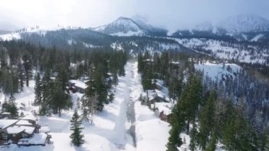 Mamut Gölü Kayak Köyü güneşli kış gününde güzel karlı dağlarda sinema arka planıyla. Büyük dağ kulübesi ve lüks dağ evi manzarası. California gayrimenkul, ABD emlak kavramı