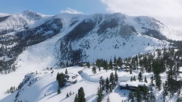 大きな山小屋と豪華なシャレーの上のエピック空気 カリフォルニア州の不動産 アメリカの財産コンセプト マンモス湖スキーリゾートビレッジ 晴れた冬の日 雪山の映画の背景と — ストック動画