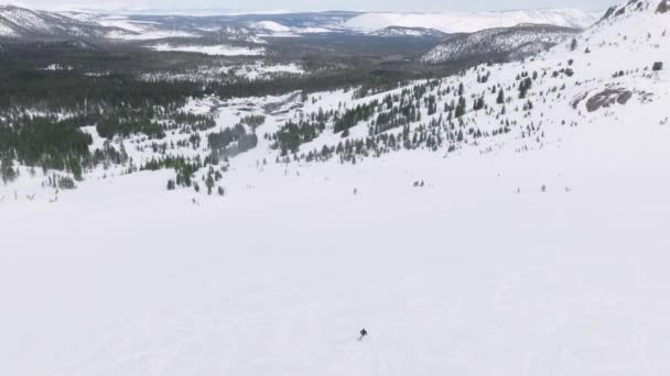 スキー場のスキー場を高速ターンで滑走するプロのスキーヤーの空中ビュー マンモス湖の急なスキー場でのスポーツスキー アスリートを追うドローン エクストリームスポーツ スキーレーススロープ — ストック動画
