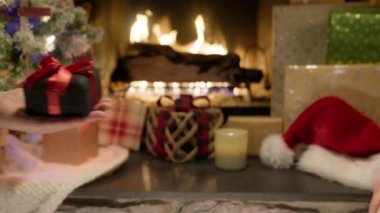 Kocanın, bayram aile partisi sırasında yanan şöminenin başında oturan eşine Noel hediyesi kutusunu verirken ellerini kapat. Güzel dekorasyon xmas ağacı ve kutlama ışıkları, kırmızı kamera.