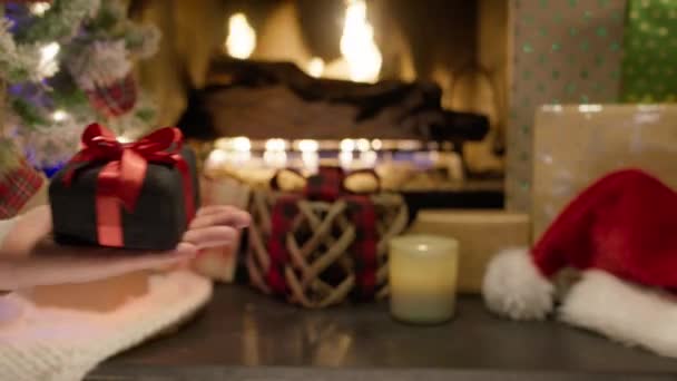家庭でのクリスマスのお祝いの間にプレゼントを交換する家族 冬の木で冬の休暇を楽しんでいる配偶者は ゆっくりとした動きで撮影されたウィンターキャビンRedで居心地の良い暖炉に座って 手を閉じます — ストック動画