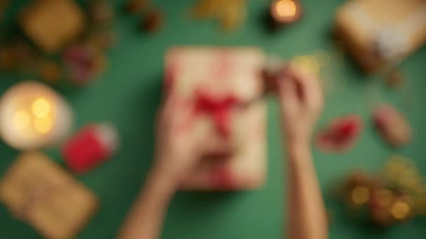 女性の手仕上げキャンディーケーン装飾トップビューのプレートギフトボックス さまざまなクリスマステーマのアイテムと美しいプレゼントのための休日の供給 フォーカス4Kを変更する美しいクラフトスペース — ストック動画