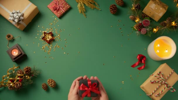 弓で赤い絹のリボンで包まれた小さなエレガントな黒いベルベットの宝石箱で贈り物を保持するハンサムな男性の手 愛とロマンチックなコンセプト クリスマスイブ4Kクローズアップトップビューで提案 — ストック動画